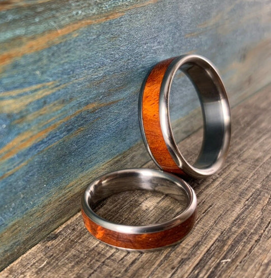 Close-up of rich figured amboyna burl wood grain on titanium couples bands