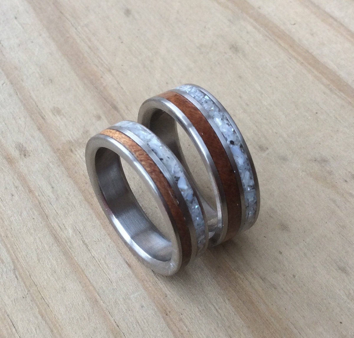 RobandLean's titanium ring with mother of pearl and ancient Kauri wood inlays, showcasing intricate design and natural materials.