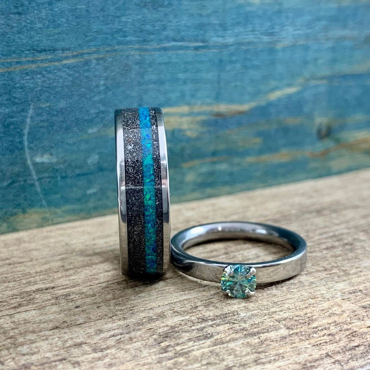 His and hers meteorite wedding band set with moissanite engagement ring, featuring sleek metal bands and sparkling stones.