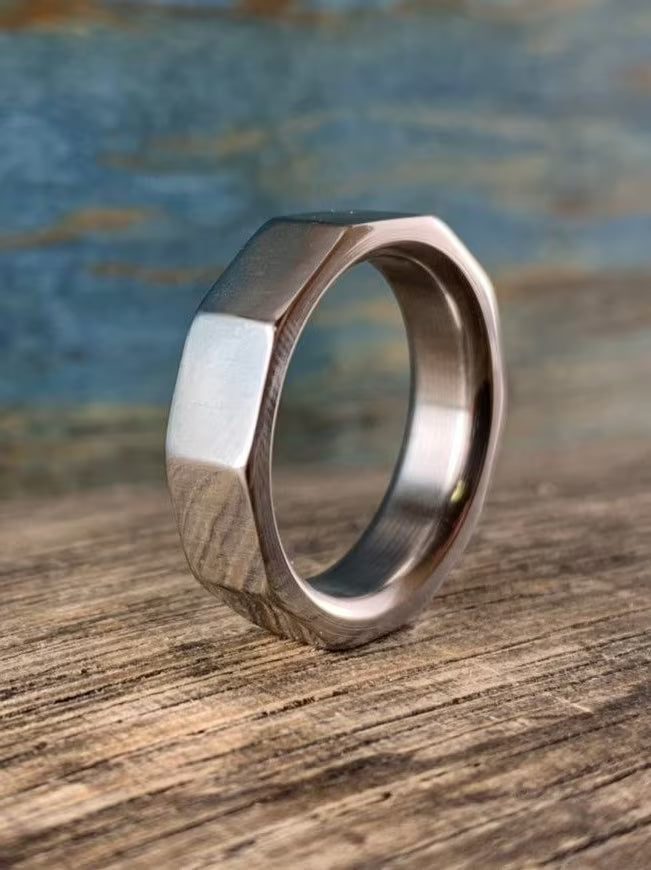 Metallic ring with geometric design on a wooden surface