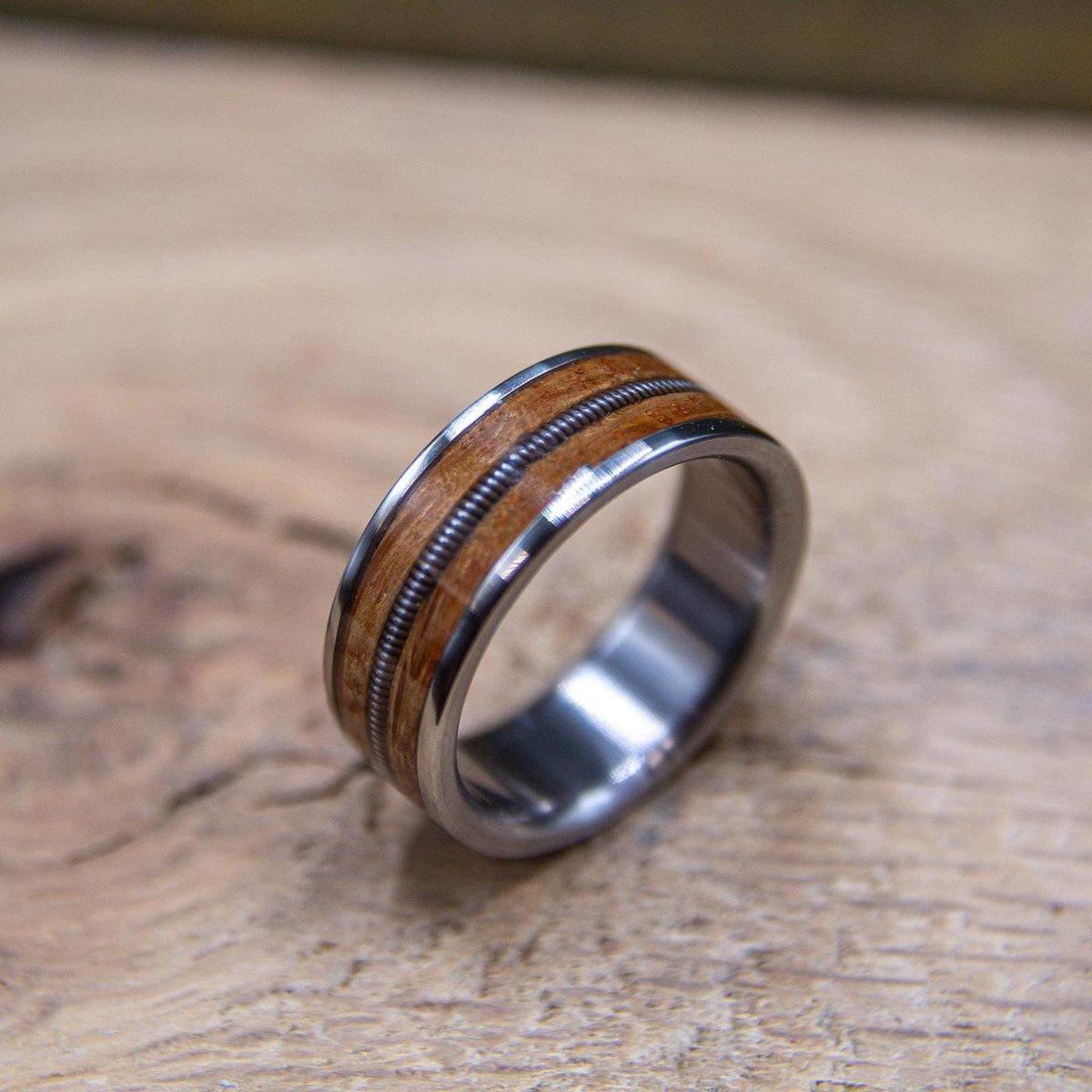 Unique titanium wedding band with wood and real guitar string inlay