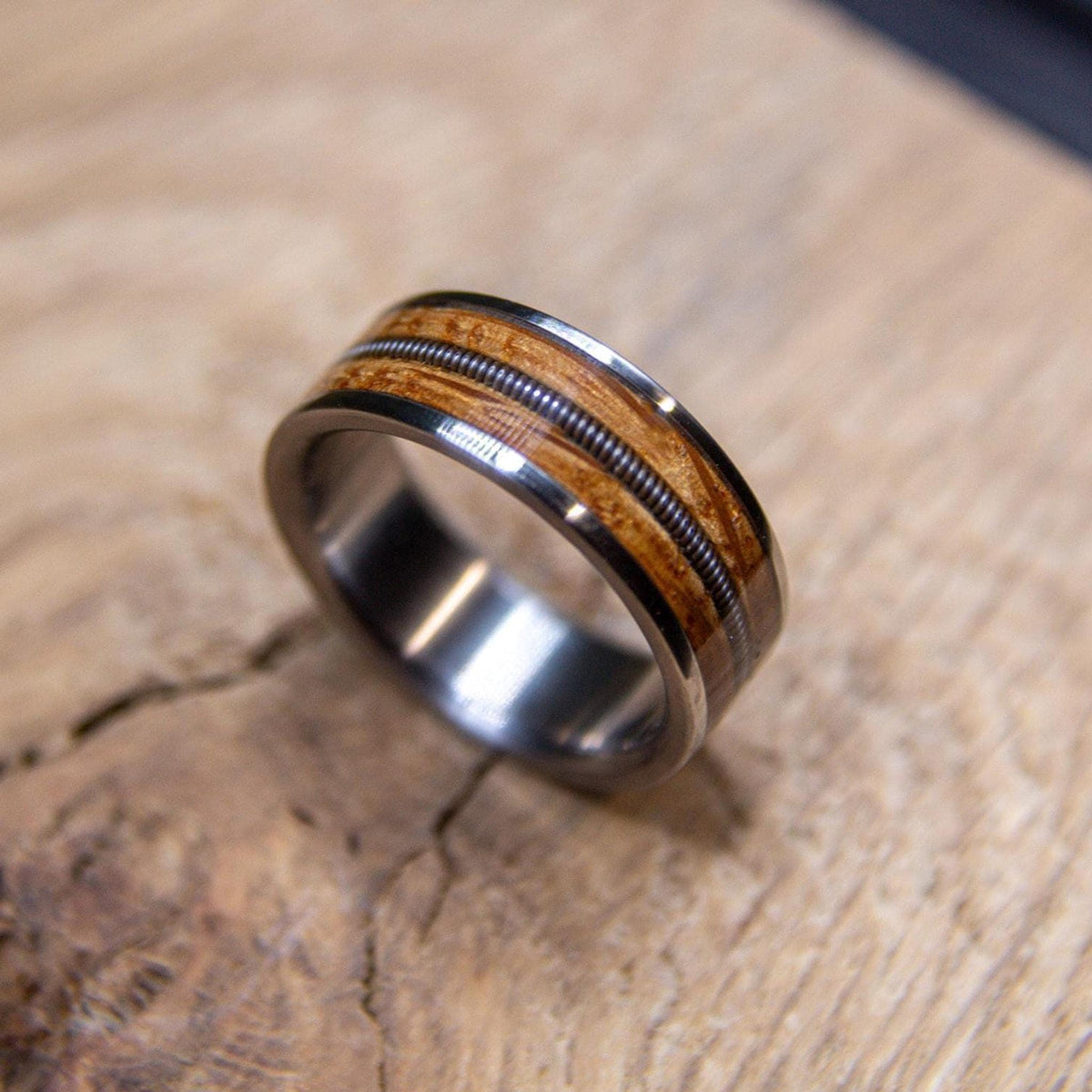 Reclaimed whiskey barrel wood wedding band handcrafted from titanium
