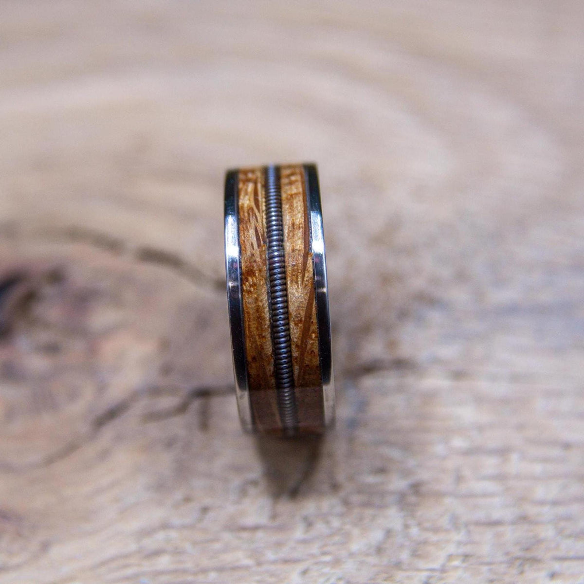 Handmade whiskey barrel and guitar string ring with polished titanium edges
