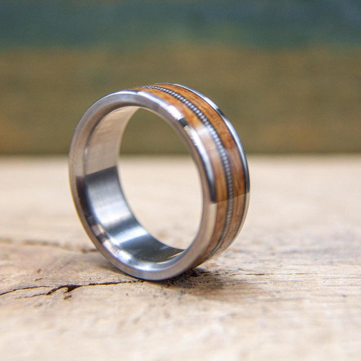 Handmade titanium wedding band featuring whiskey barrel wood and guitar string