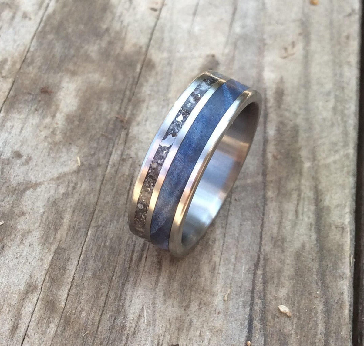 The titanium ring angled to display the side-by-side meteorite and blue wood inlays.