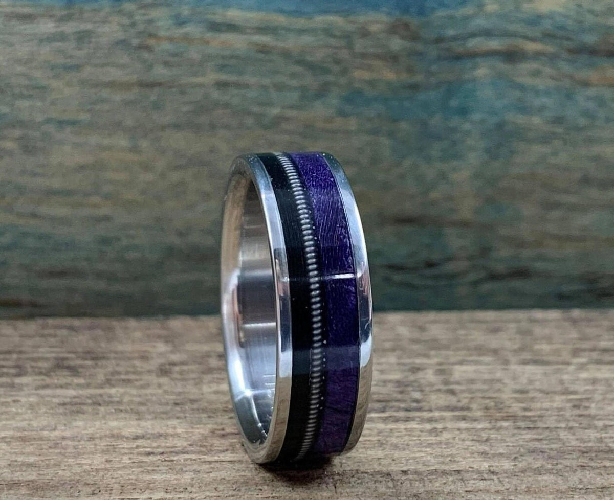 The ring positioned vertically to show the smooth polished interior lining next to the intricate outer inlay.