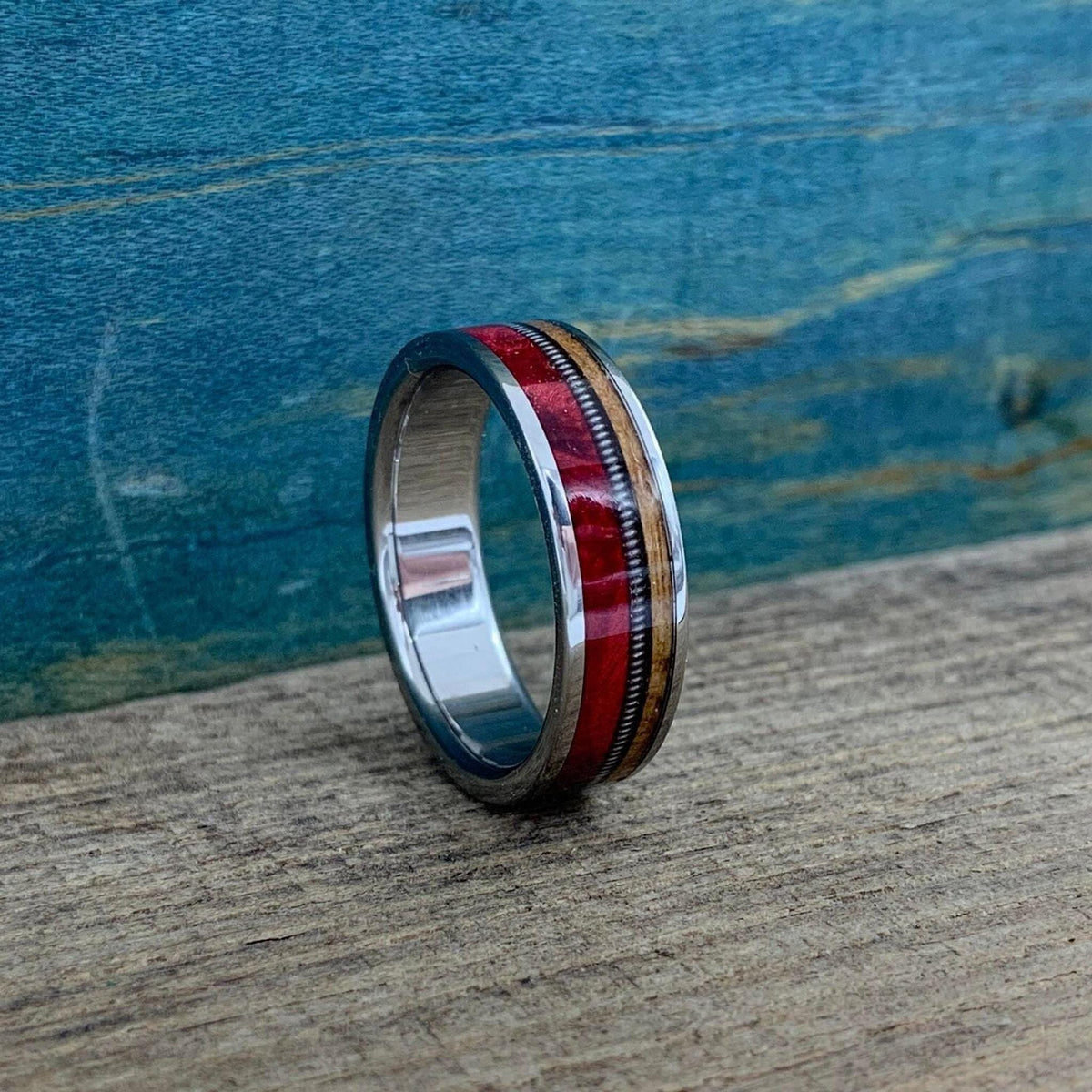 The ring is angled slightly to the right, showing the reflective silver inner band and the outer decorative inlays clearly.
