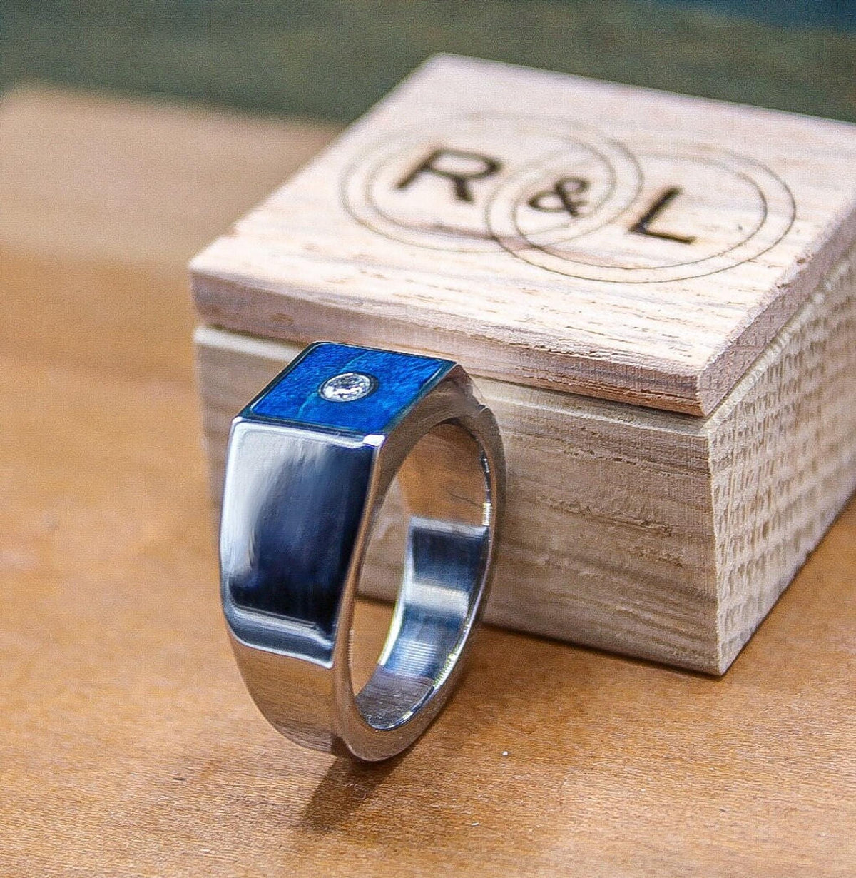 Custom made men's signet ring with blue box elder wood and bezel set moissanite.
