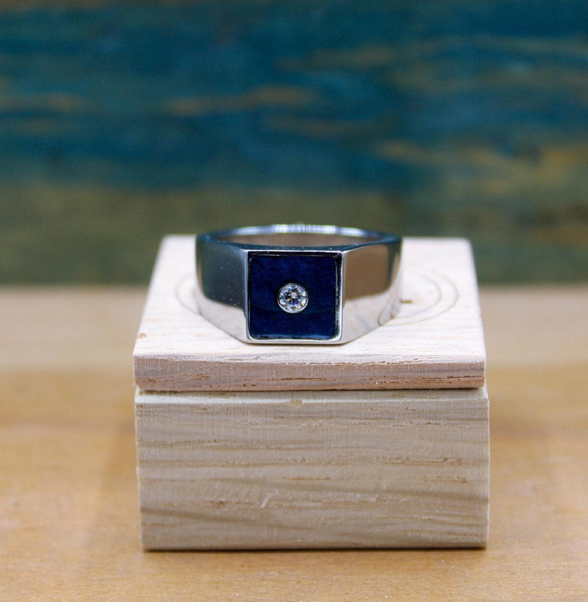Custom made men's signet ring with blue box elder wood and bezel set moissanite.