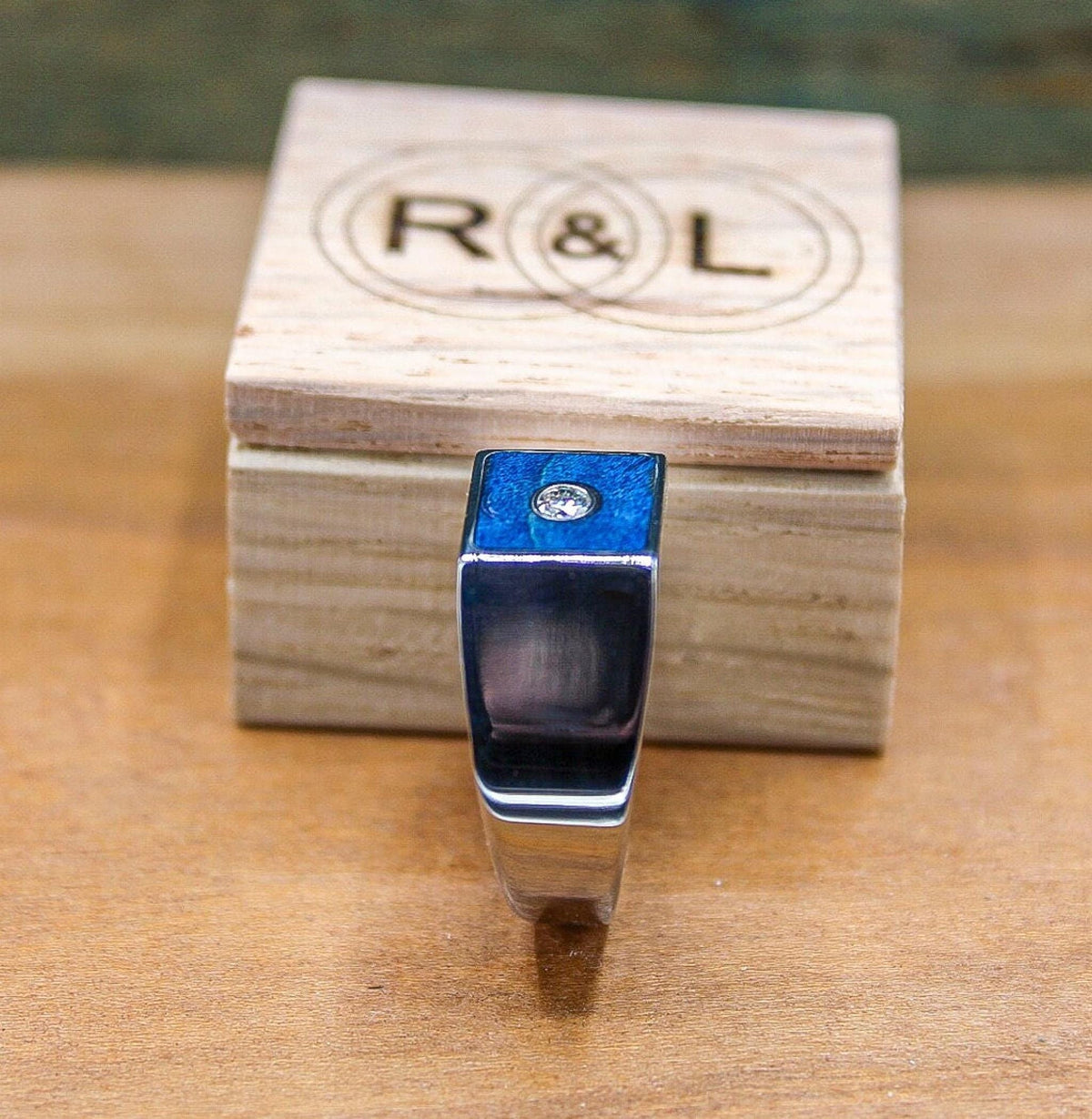 Custom made men's signet ring with blue box elder wood and bezel set moissanite.