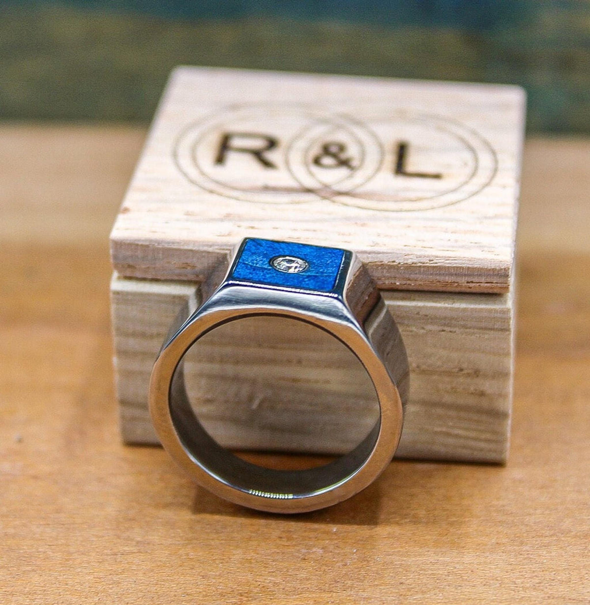 Custom made men's signet ring with blue box elder wood and bezel set moissanite.