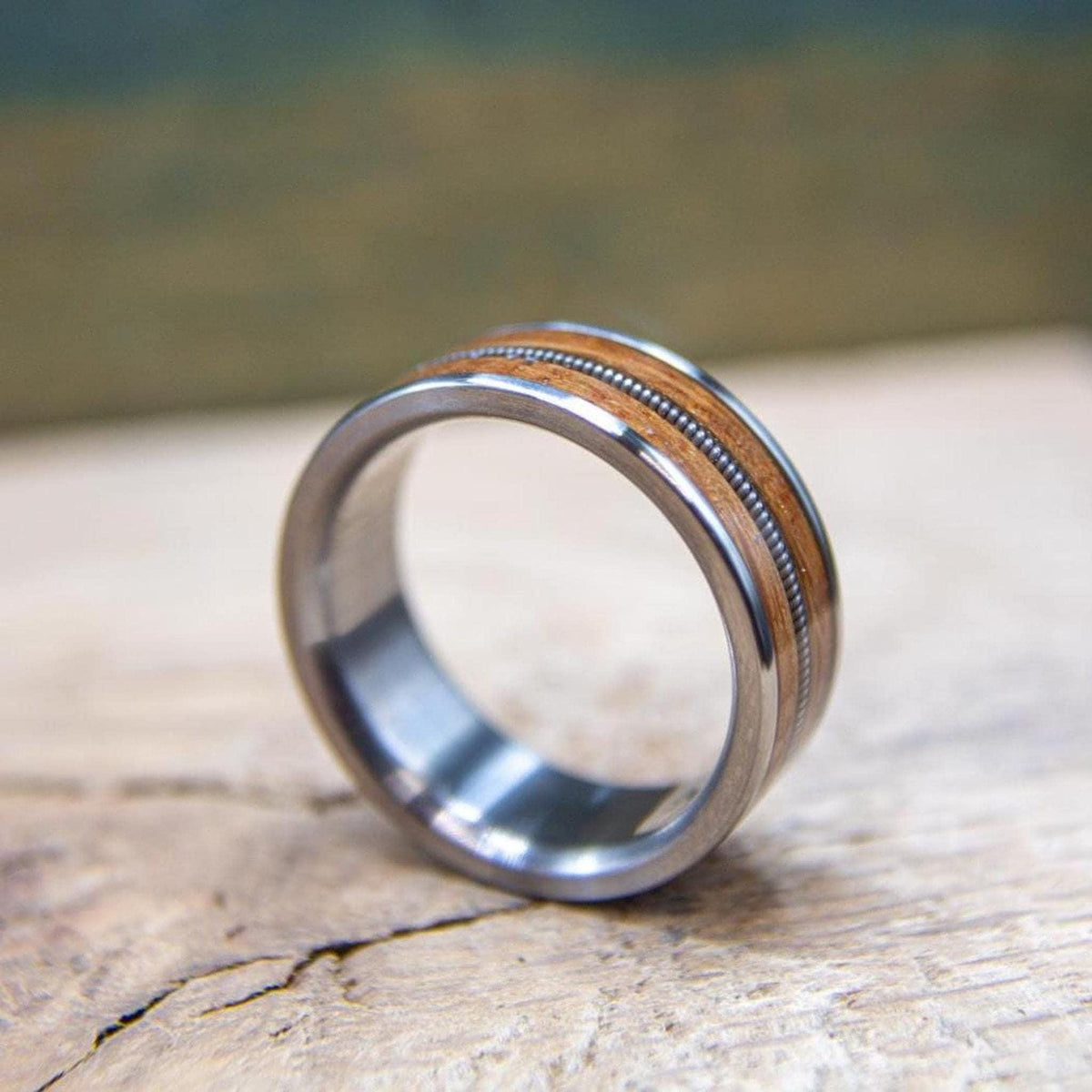 Titanium ring with aged whiskey barrel wood and retired guitar string inlay