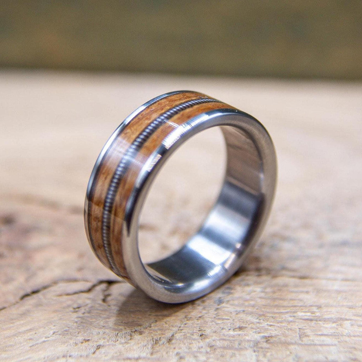 Close-up of reclaimed whiskey barrel wood and guitar string set in titanium