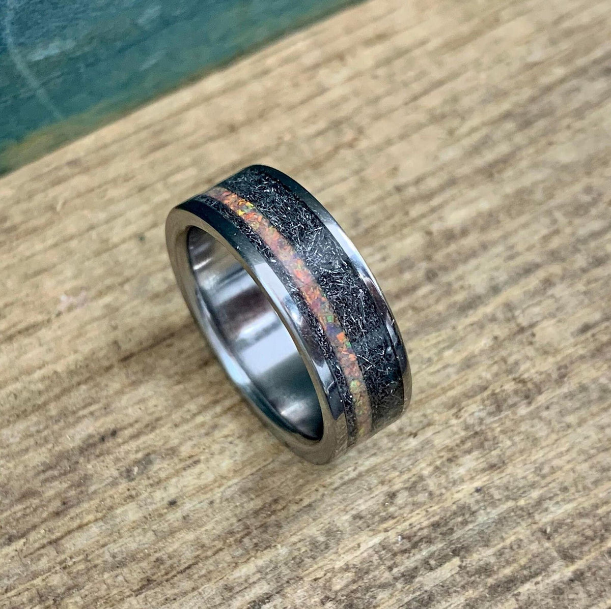 Slightly elevated view of the unique wedding band resting on textured wood.