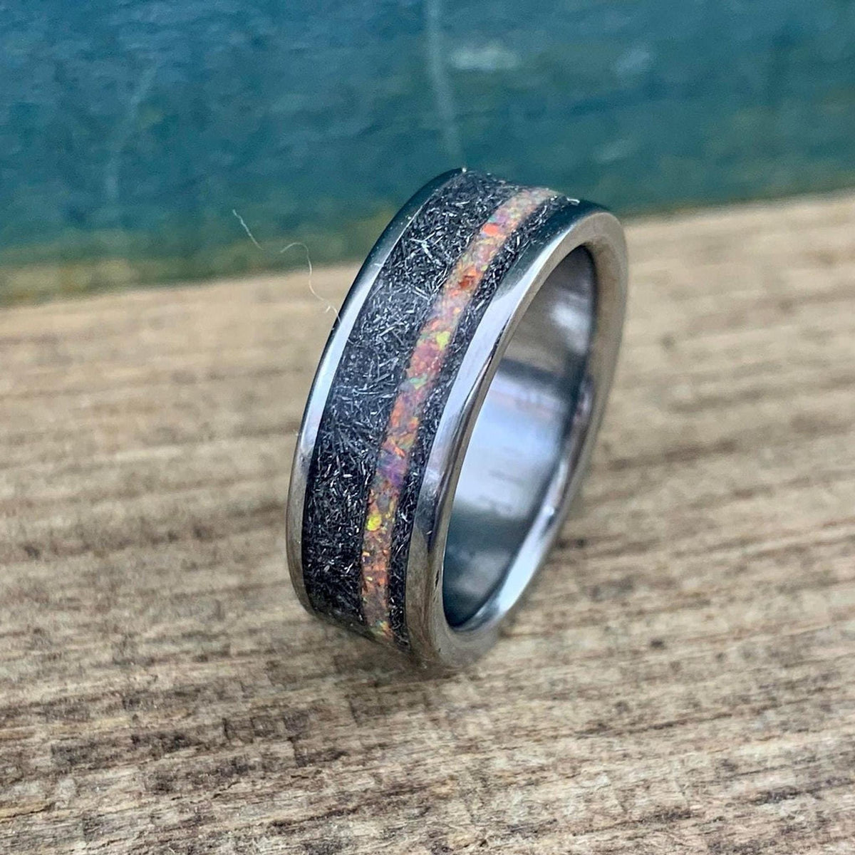Side perspective of the titanium ring emphasizing the polished interior band and the rough meteorite exterior texture.