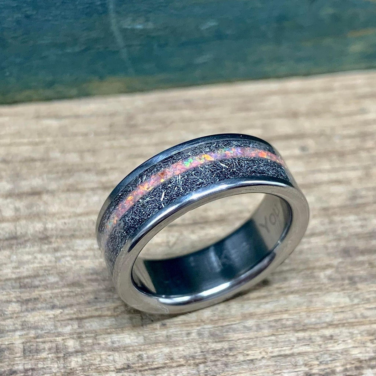 Close-up of the ring tilted slightly toward the camera, revealing engraved text visible on the interior polished surface.