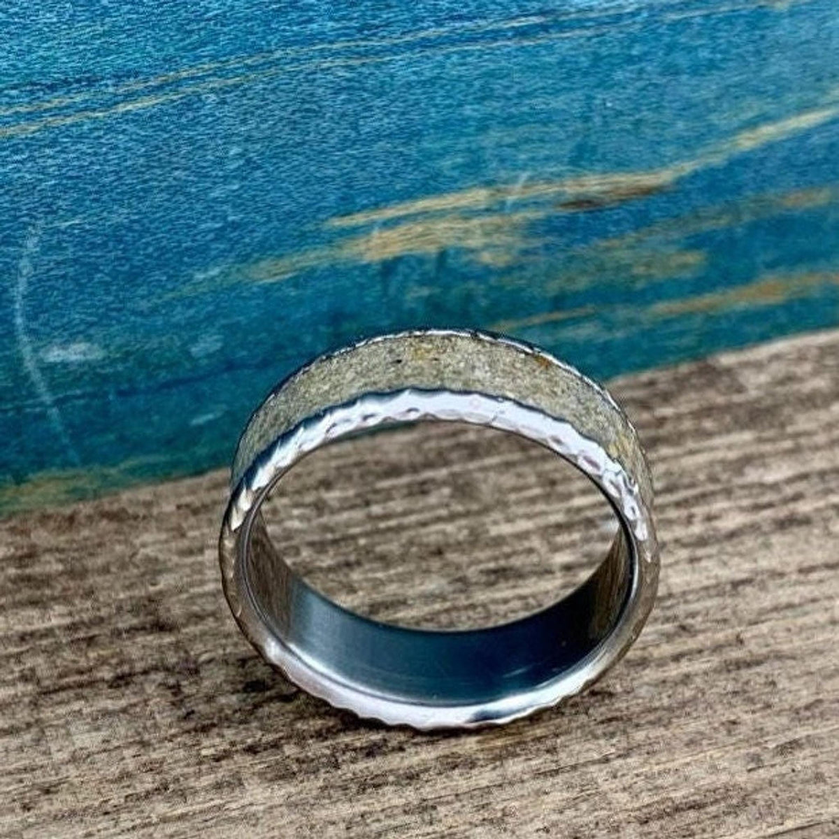 A close-up shot of the textured ring lying flat, showcasing its concrete center and metallic edges.