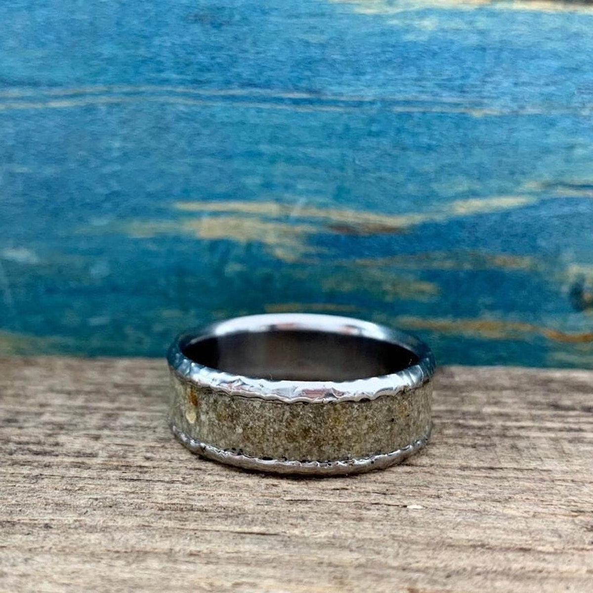 The ring lying flat horizontally, showing the continuous concrete inlay banded by metal.