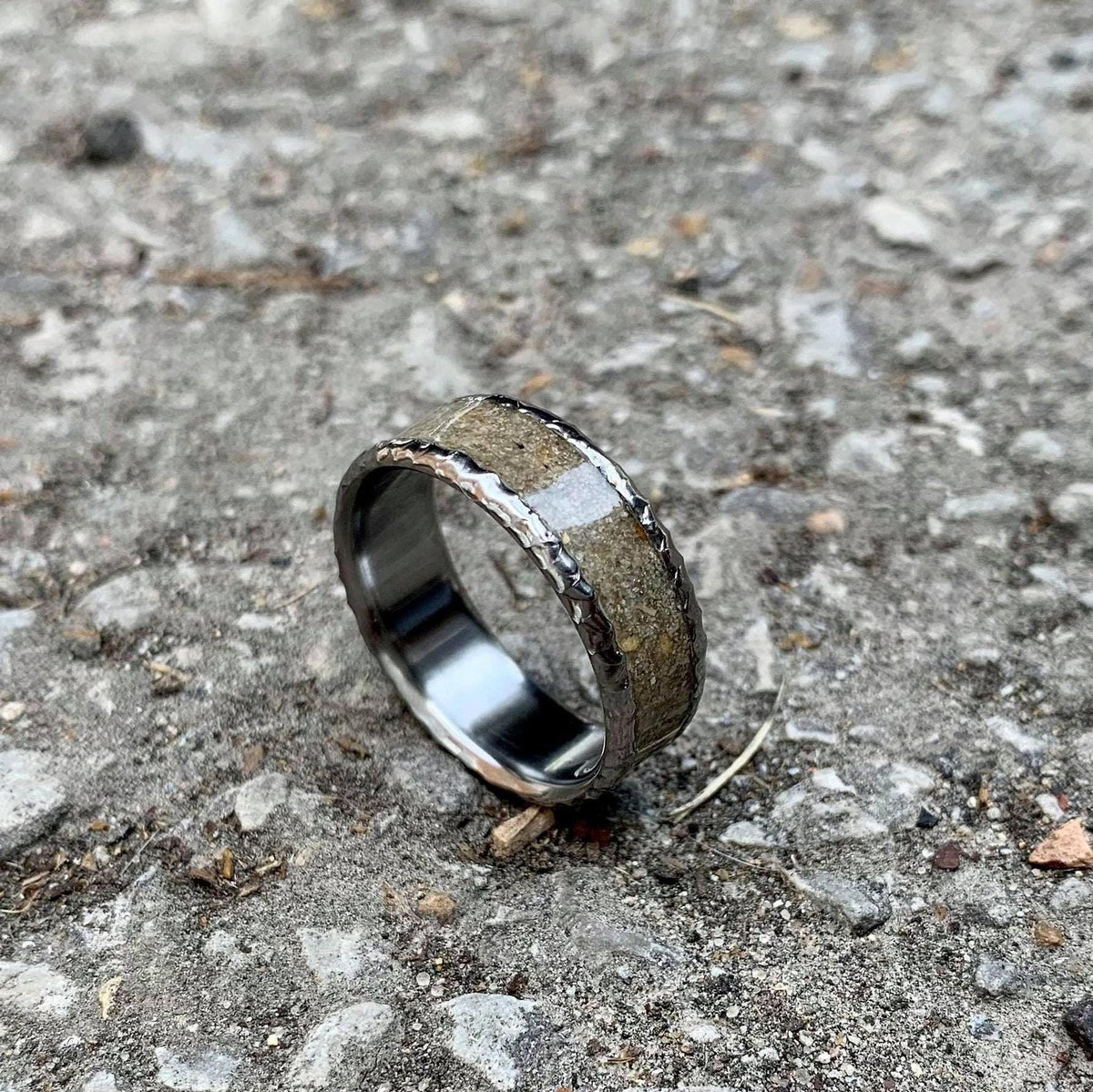 The ring resting on a rough concrete ground surface outdoors.