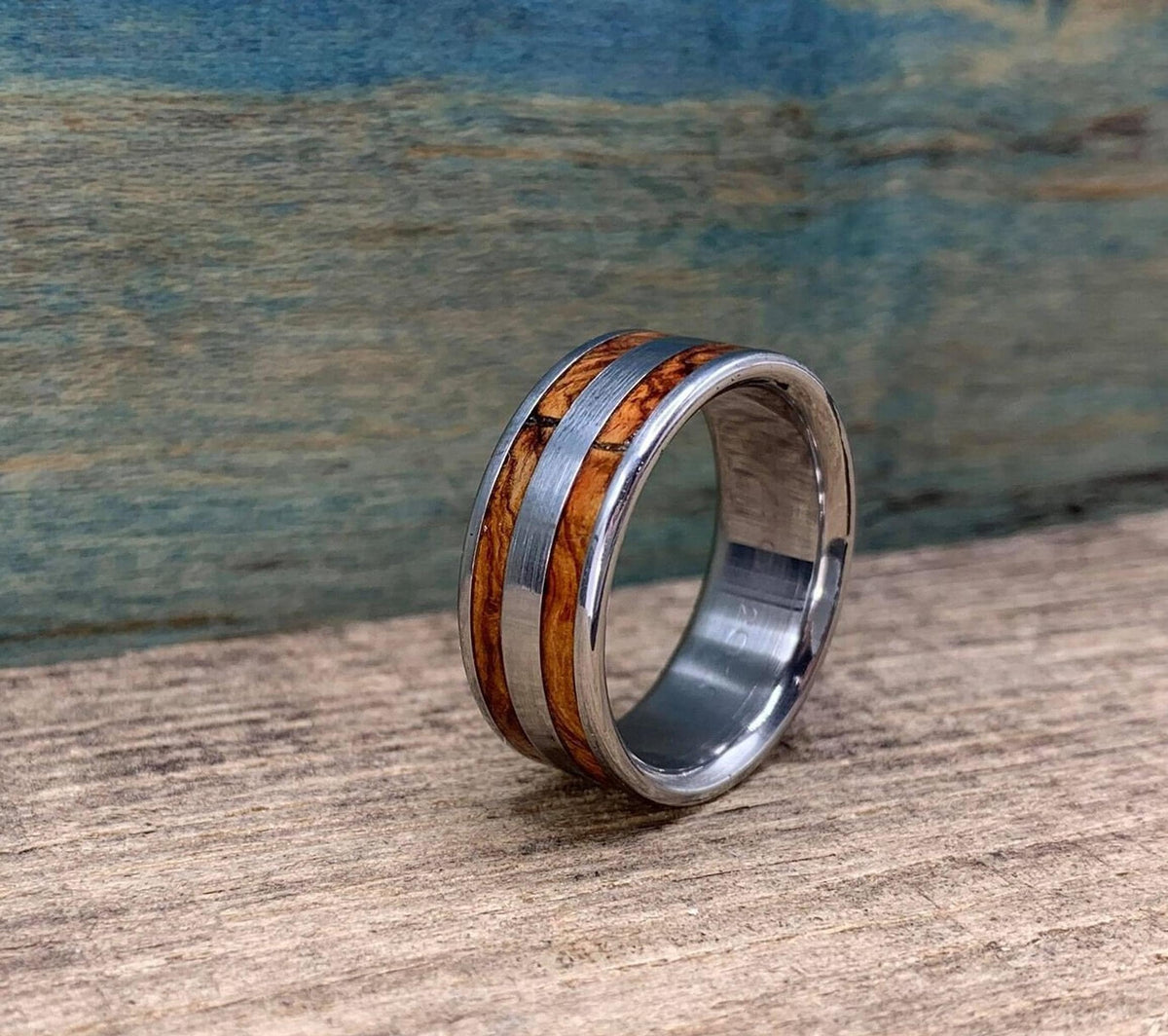 A close-up shot of the ring standing upright, highlighting the grain of the wood inlay.