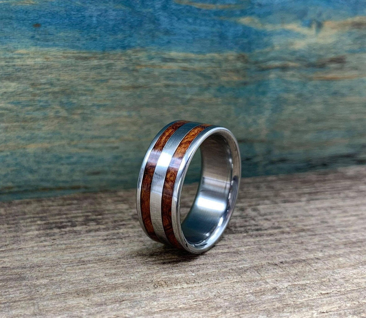 A side profile of the ring standing on the textured wooden board.