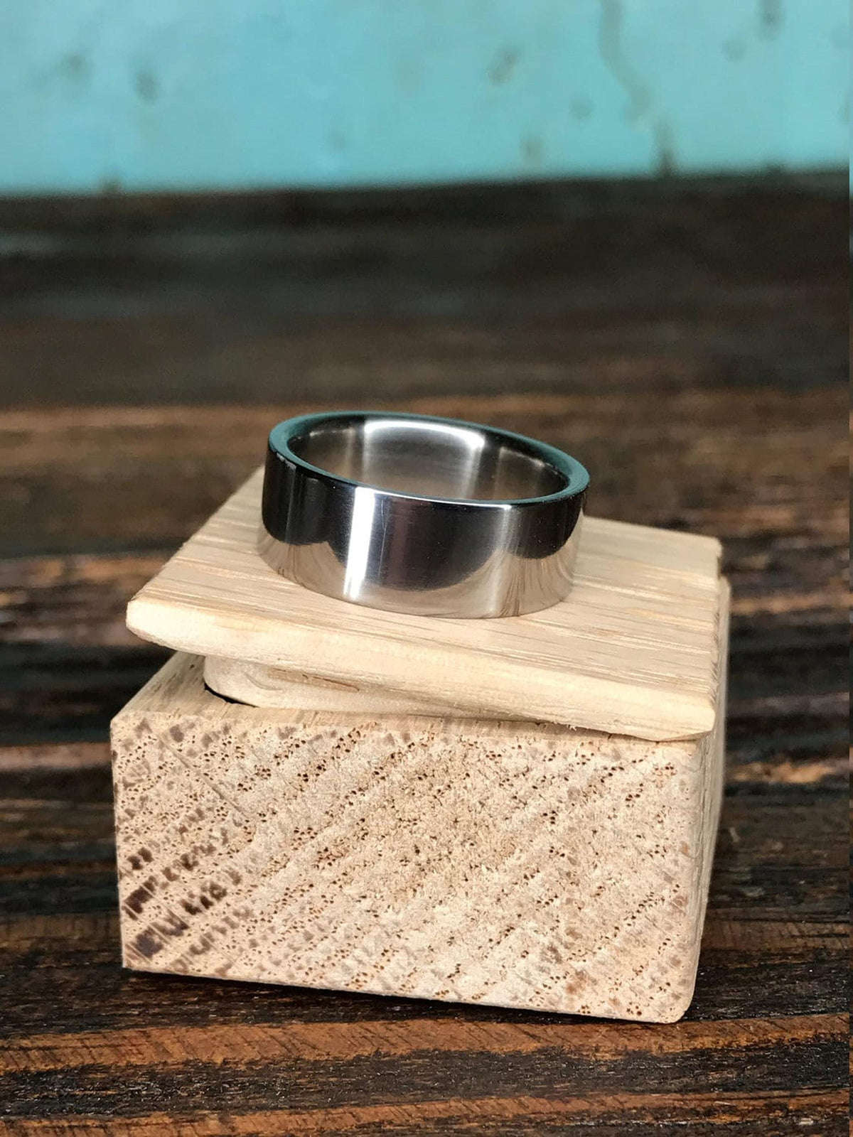 A metallic ring sitting on the lid of a small wooden block.
