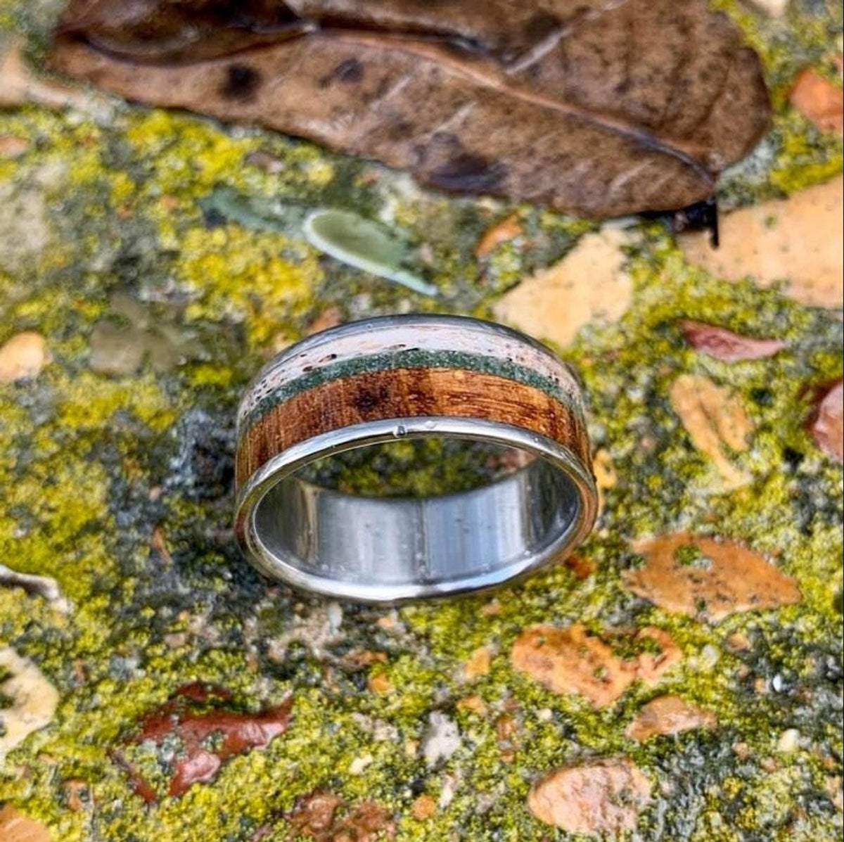 A slightly angled macro shot of the ring highlighting the textures of its wood and stone segments.
