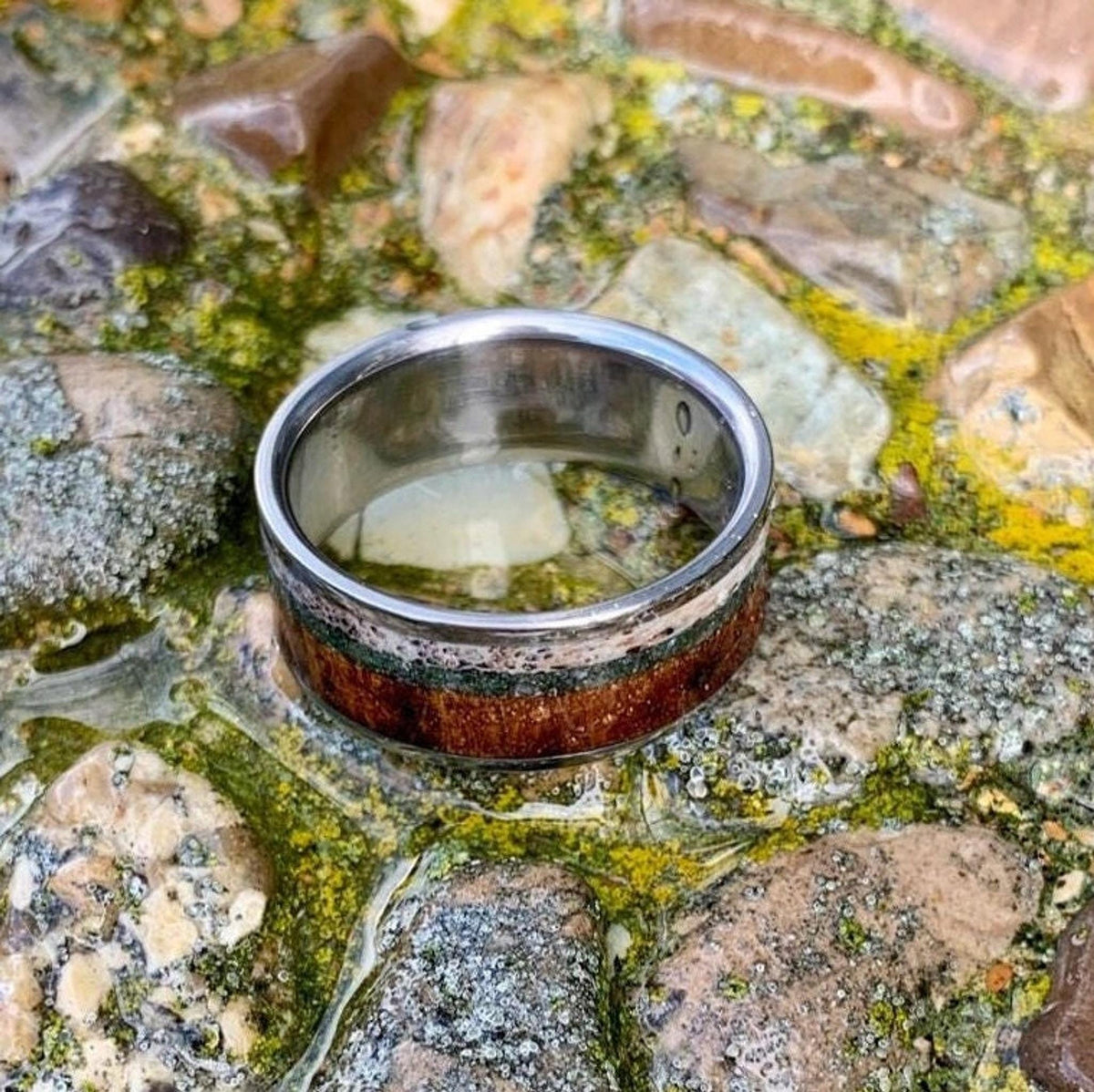 A low-angle view of the titanium band showcasing the interior metal finish alongside the exterior wood inlay.
