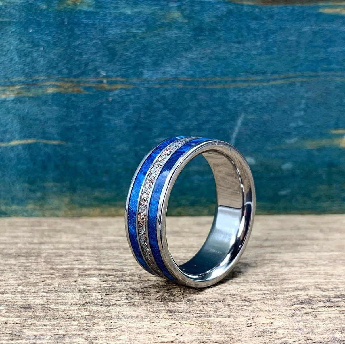 The ring is photographed upright on a wooden surface with its inner metal band visible.