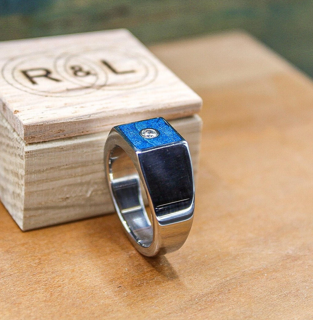Custom made men's signet ring with blue box elder wood and bezel set moissanite.