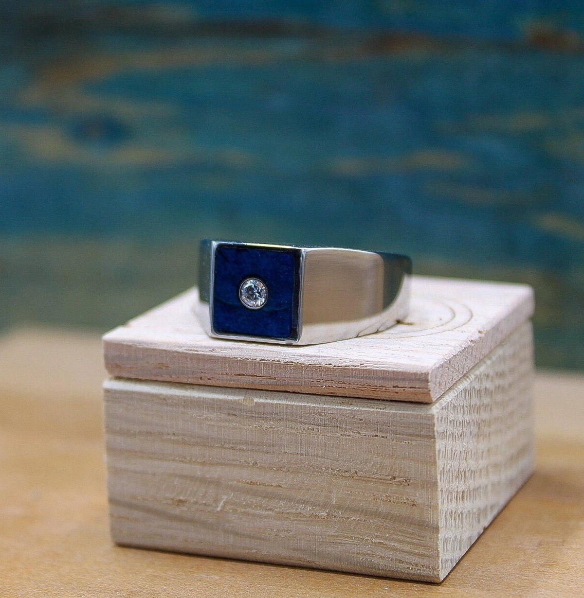 Custom made men's signet ring with blue box elder wood and bezel set moissanite.