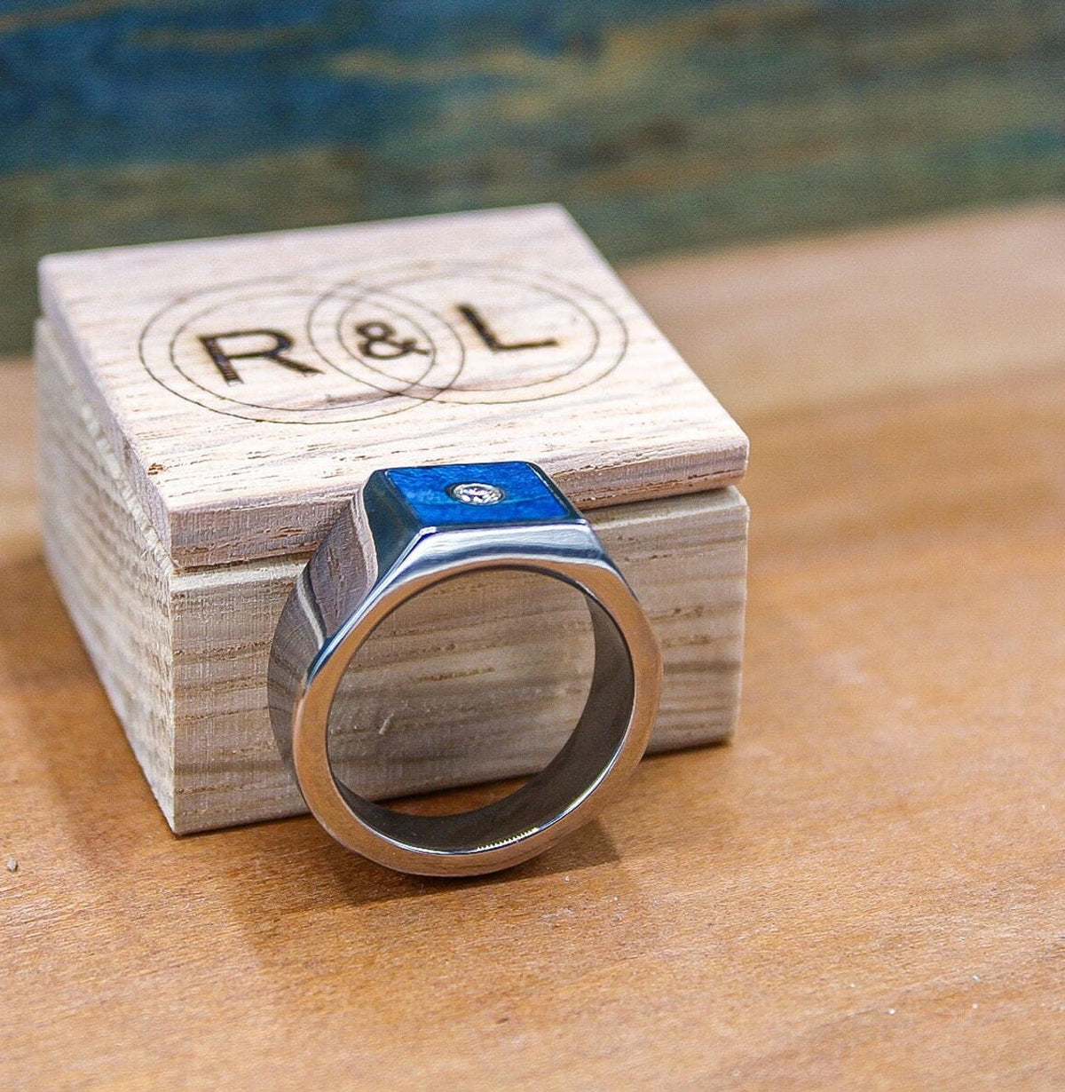 Custom made men's signet ring with blue box elder wood and bezel set moissanite.