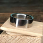 A polished metal ring rests on top of a small wooden block.