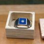 Custom made men's signet ring with blue box elder wood and bezel set moissanite.