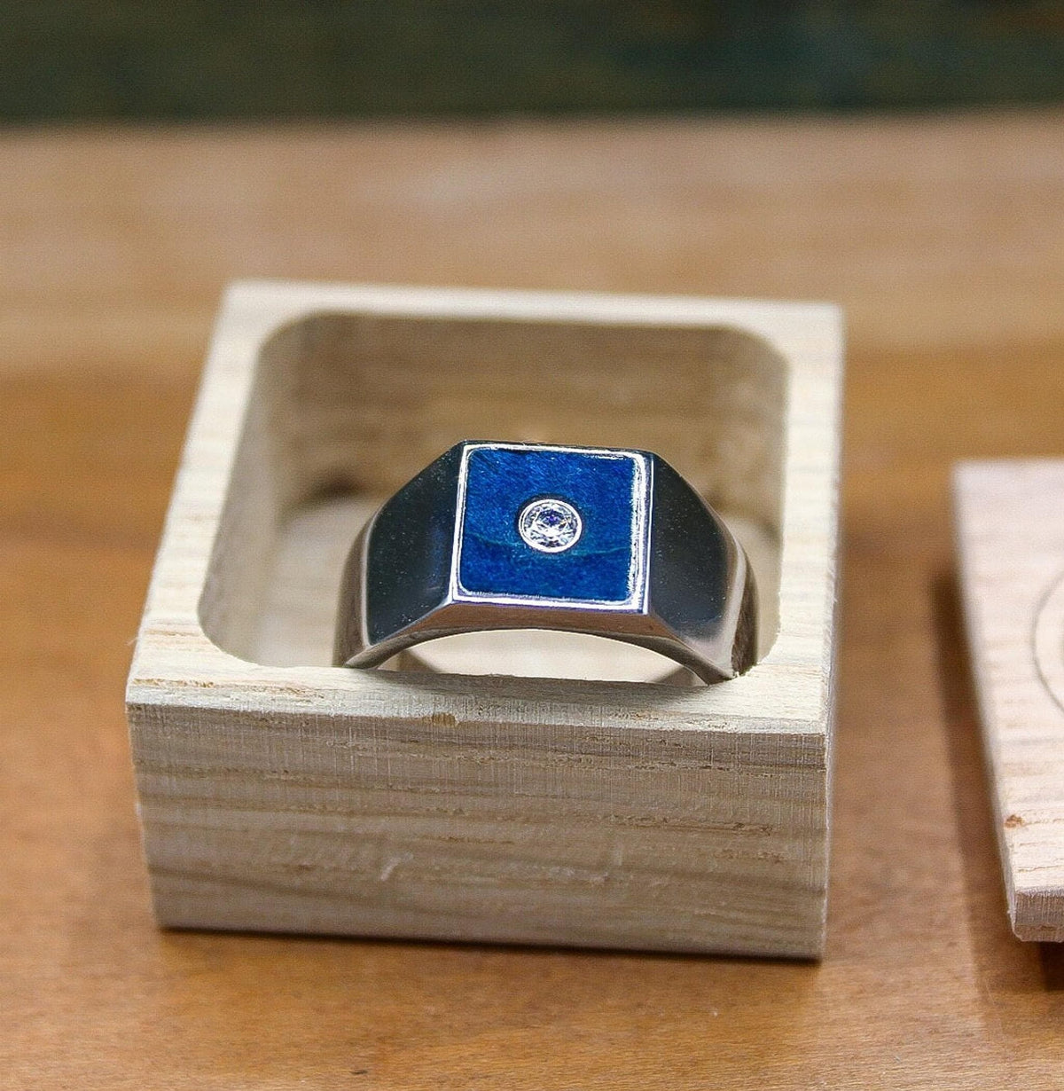 Custom made men's signet ring with blue box elder wood and bezel set moissanite.