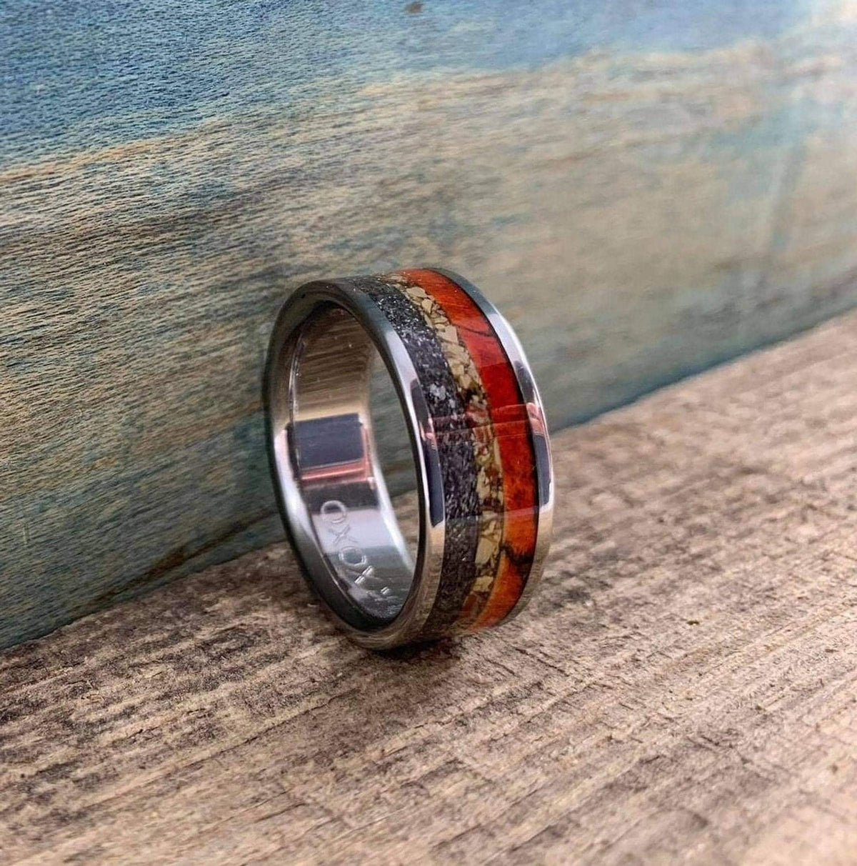 The ring standing upright on a wooden surface against a blue rustic background.