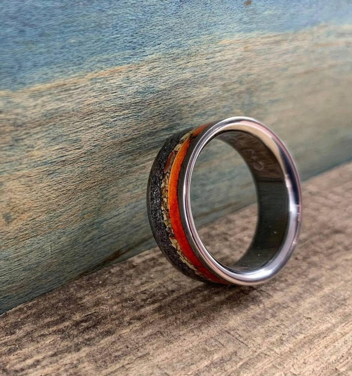 An angled view of the ring standing on its side on a rustic wooden board, showing its polished interior.