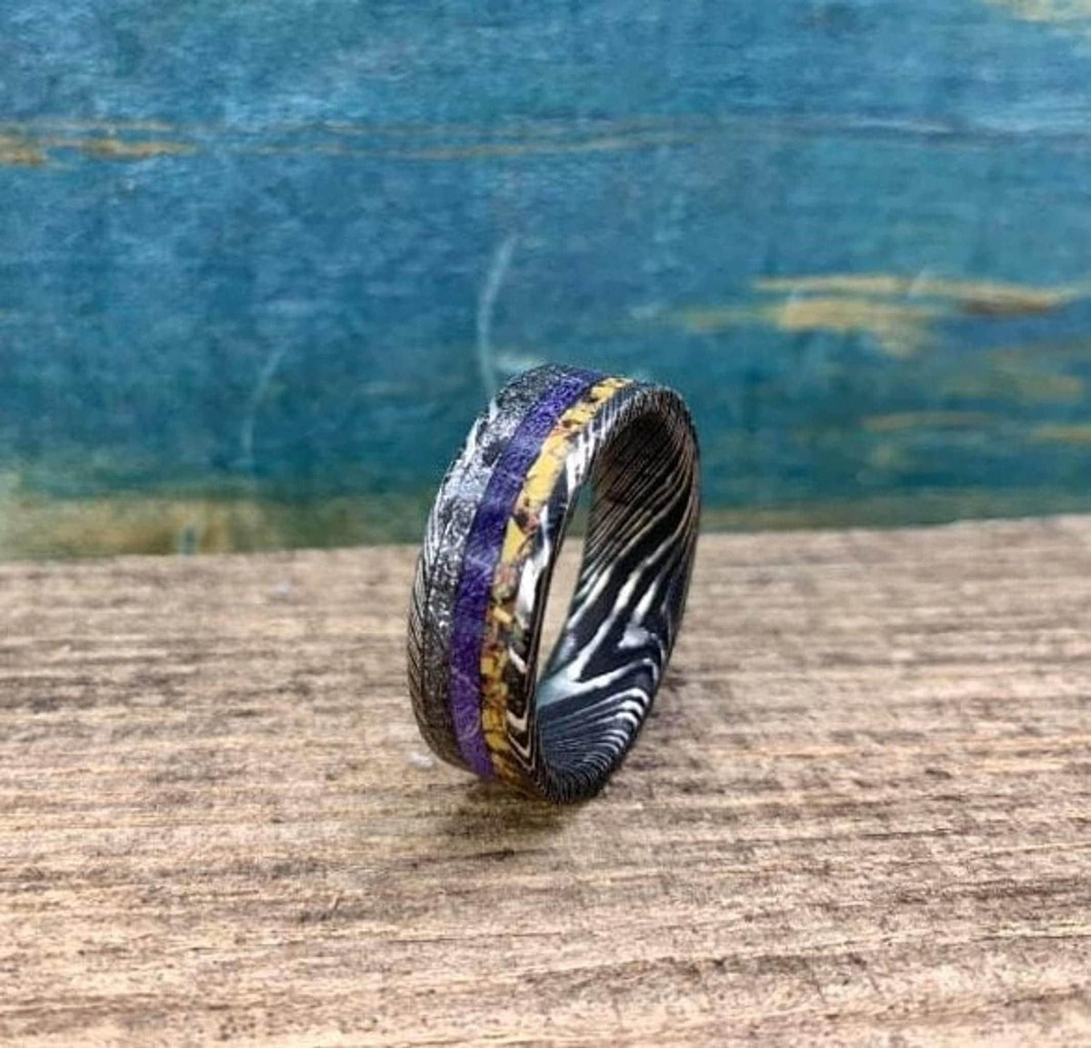 Another side angle of the ring showcasing its dark metallic band and central purple stripe.