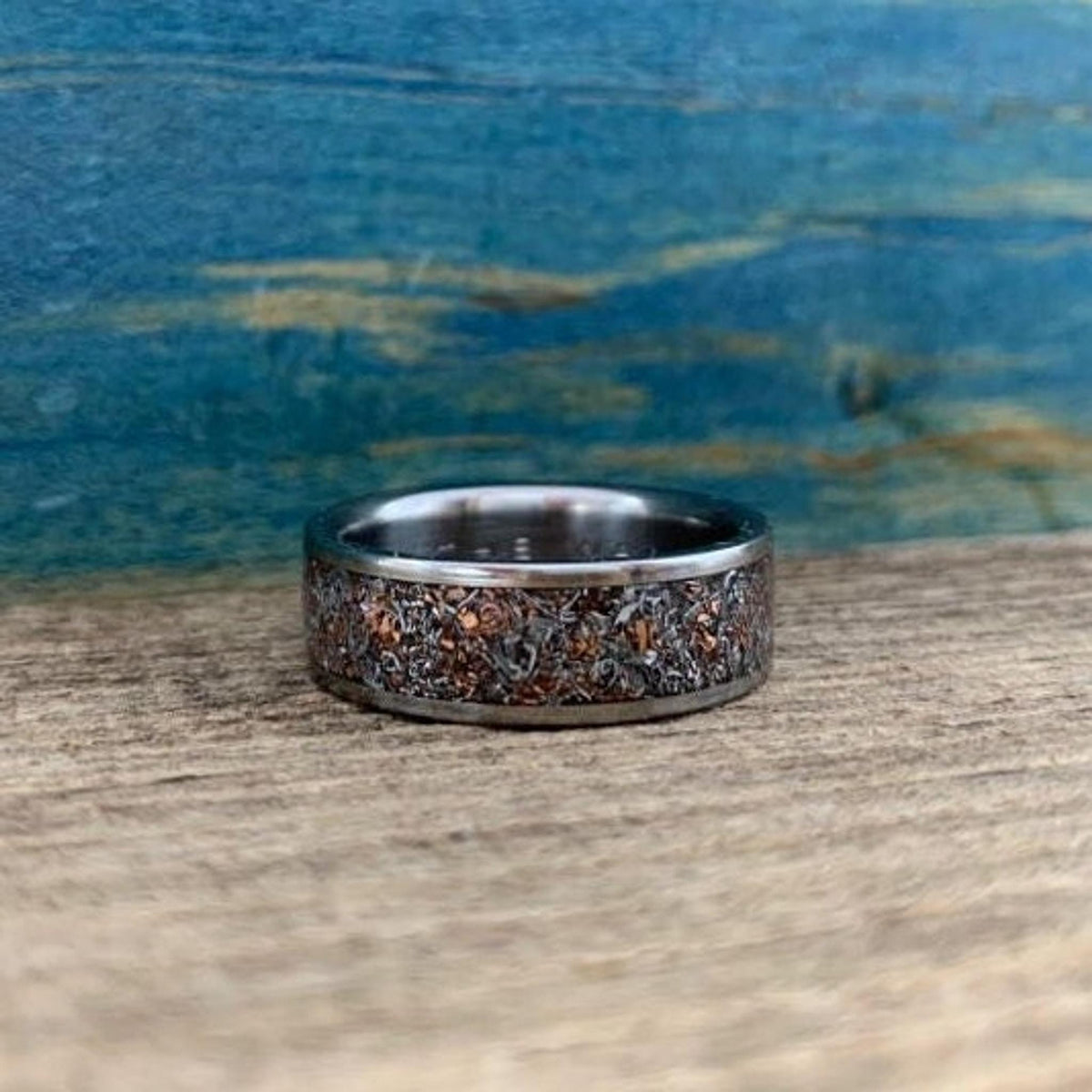 A ring viewed from the front, highlighting the detailed texture of the mixed metal inlay.