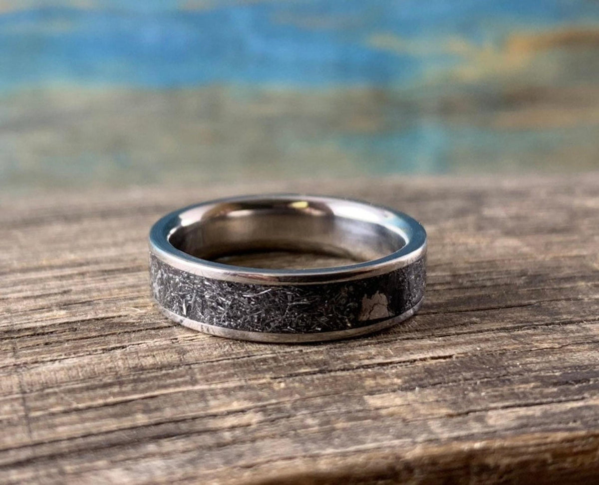 A flat-resting view of the metallic ring displaying the crystalline texture of the meteorite inlay around its circumference.