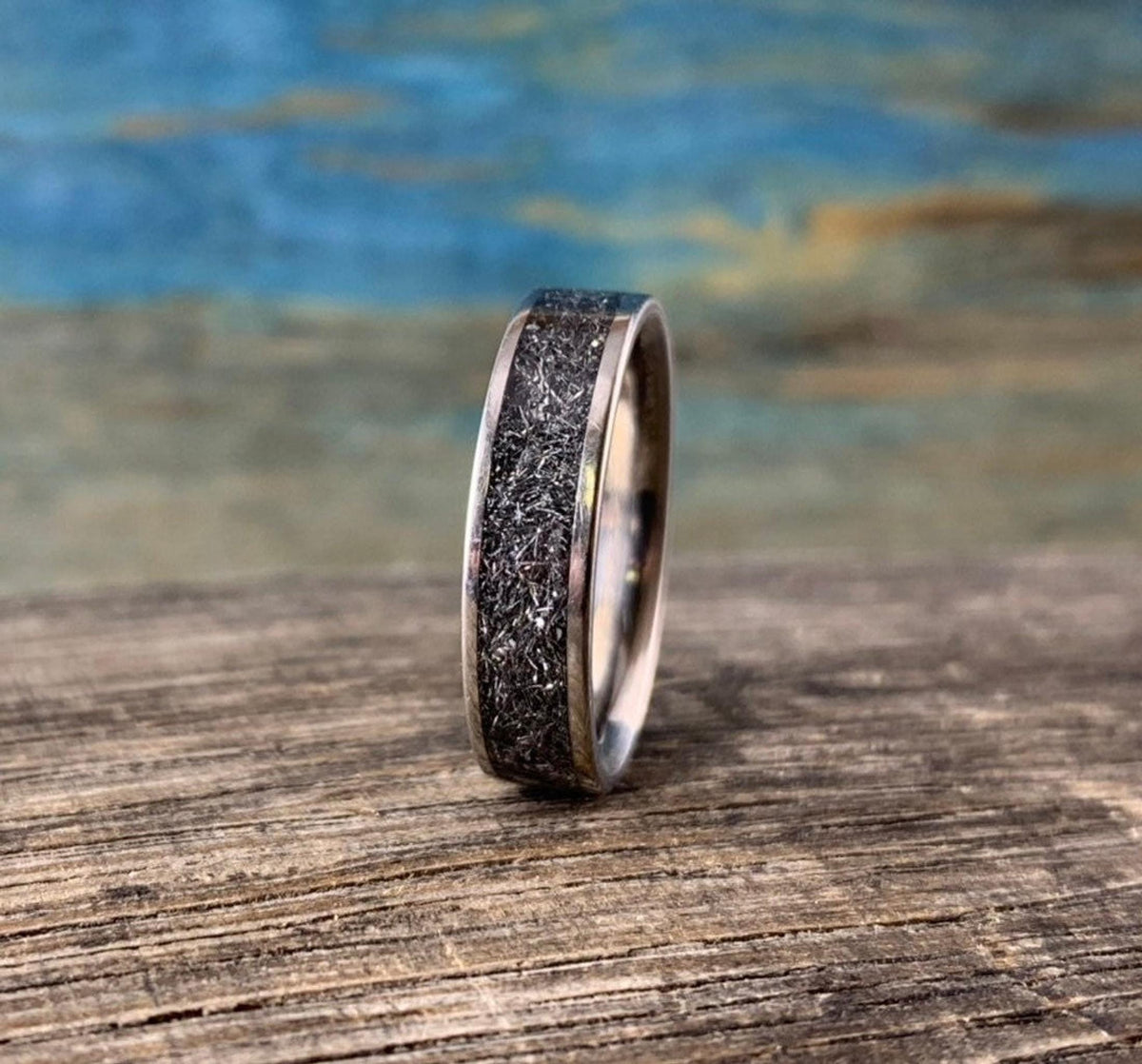 A straight-on profile shot of the upright titanium band highlighting the width and distinct pattern of the meteorite center.