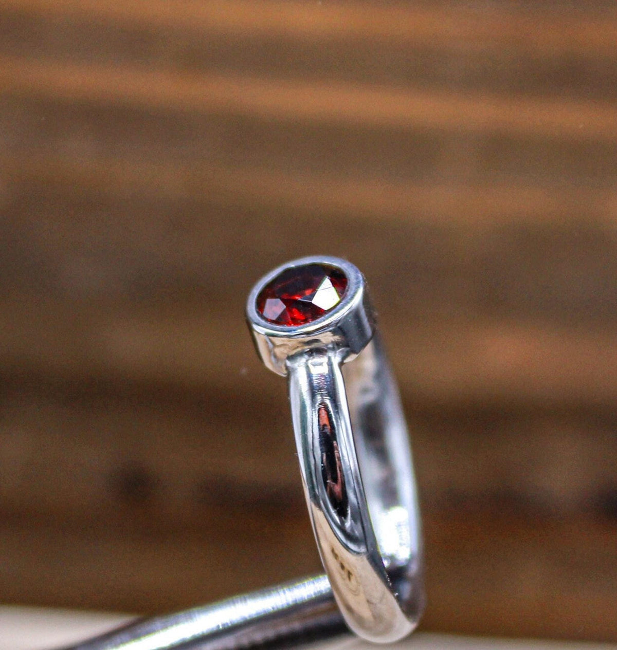 Handmade garnet bezel set titanium ring. 5mm round faceted garnet ring. Custom made titanium wedding band.