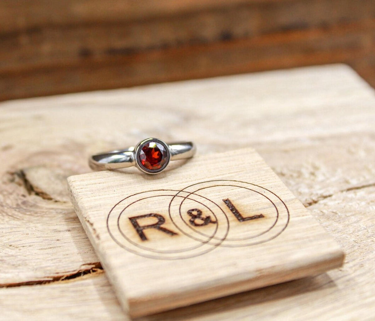 Handmade garnet bezel set titanium ring. 5mm round faceted garnet ring. Custom made titanium wedding band.