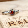 Handmade garnet bezel set titanium ring. 5mm round faceted garnet ring. Custom made titanium wedding band.
