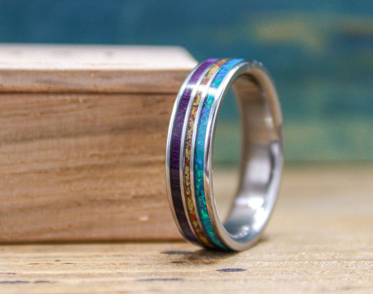Made to order men's titanium wedding ring with dinosaur bone, opal and purple wood inlays.