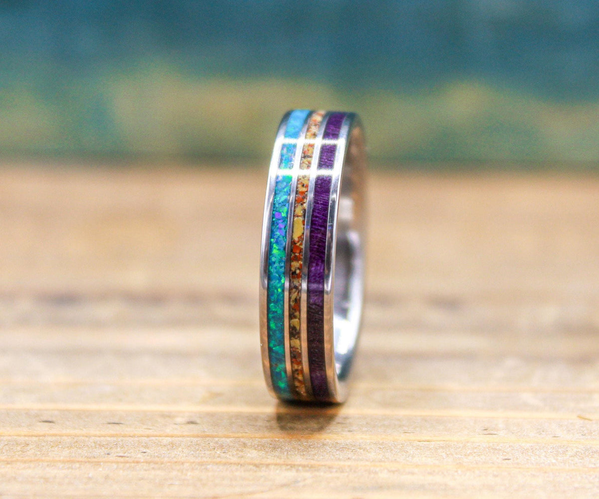 Made to order men's titanium wedding ring with dinosaur bone, opal and purple wood inlays.