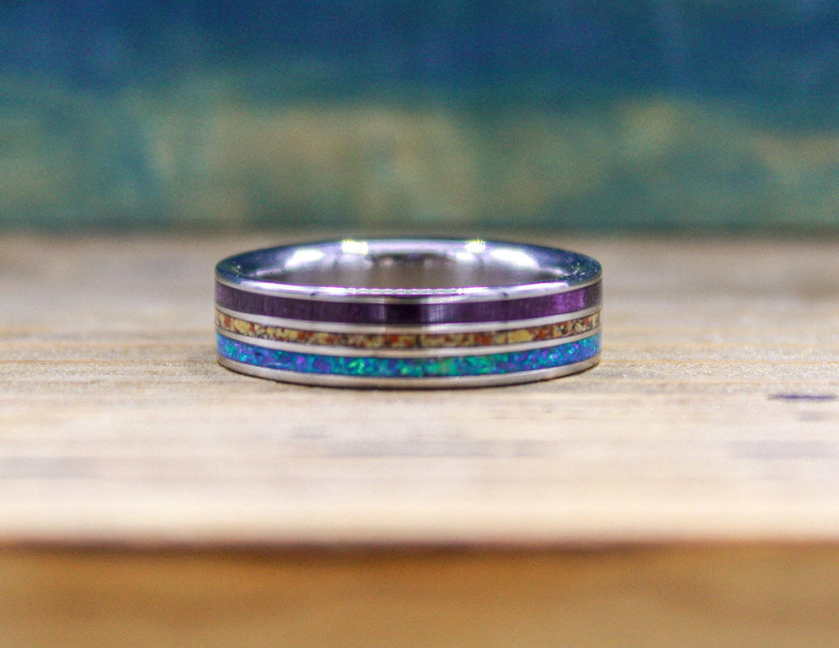Made to order men's titanium wedding ring with dinosaur bone, opal and purple wood inlays.