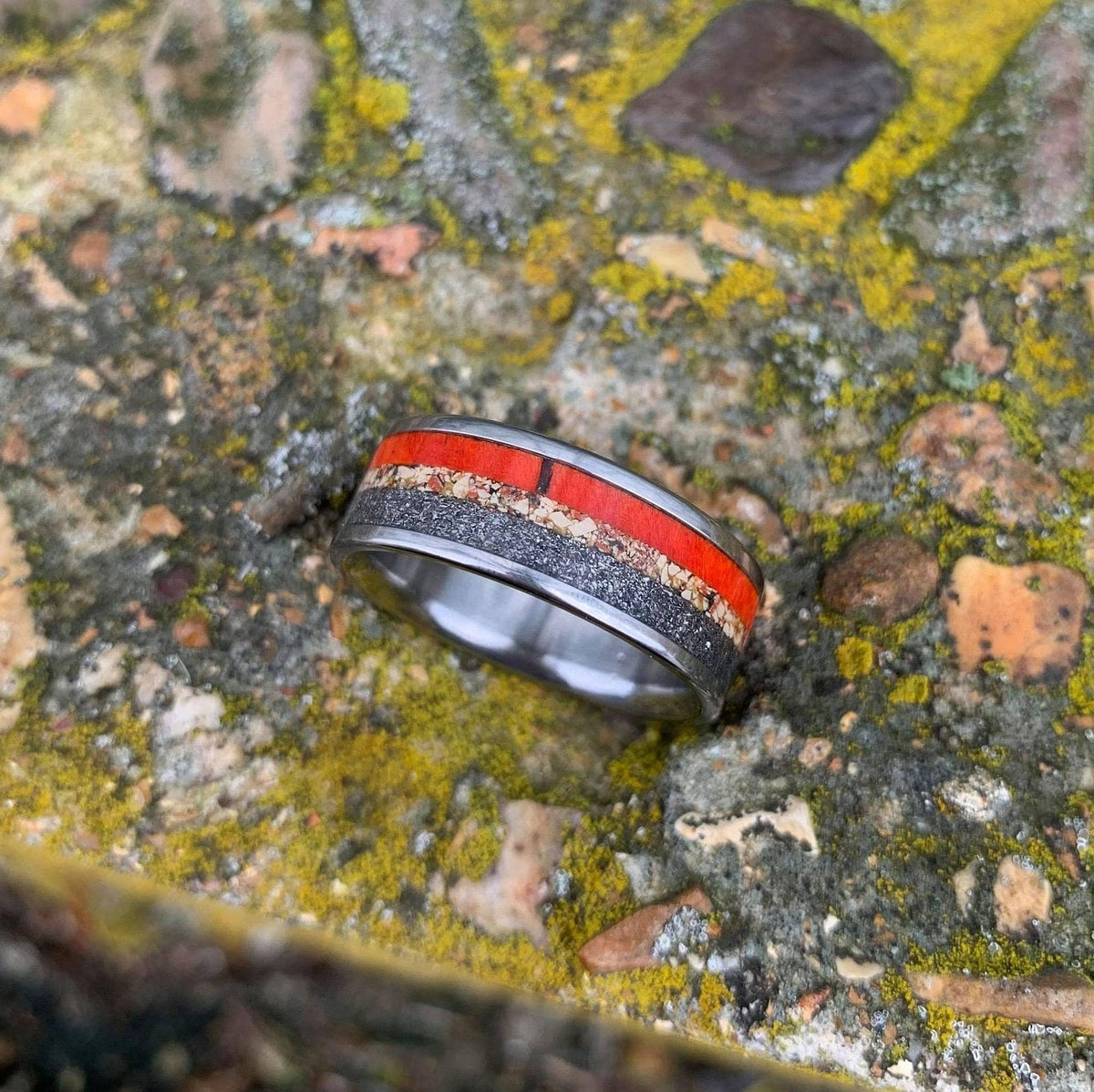 A top-down view showcasing the colorful band of dinosaur bone, meteorite, and wood on a textured rock.
