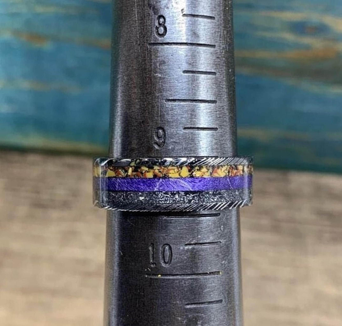 The ring positioned on a metal ring mandrel showing a size between 9 and 9.5.