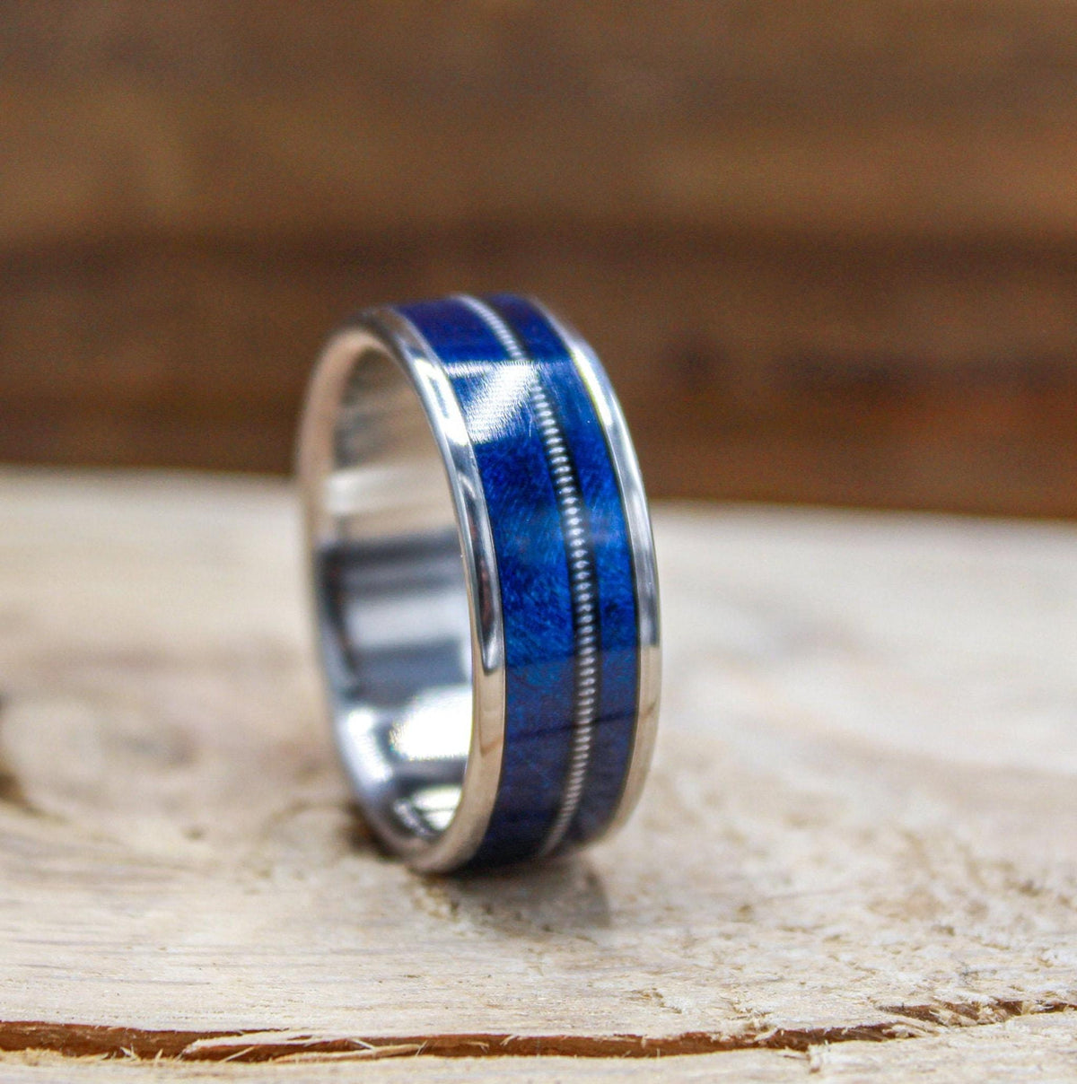 Titanium and blue wood ring for men with guitar string inlay.